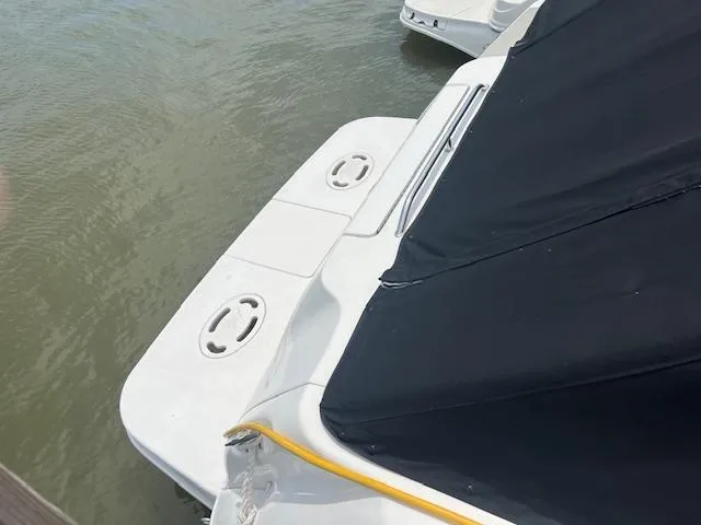 Slide: The Image of 1998 Sea Ray 290 Sundancer boat with black cover on water. - 3