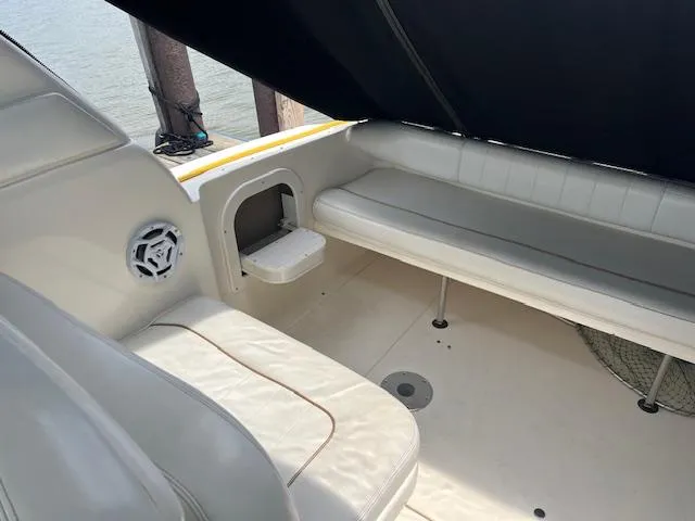 Slide: The Image of 1998 Sea Ray 290 Sundancer boat interior with white seating and speaker. - 8