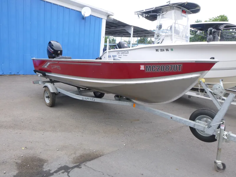 Slide: The Image of 2022 Lund SSV-16 boat on trailer, red and silver, parked outdoors. - 3