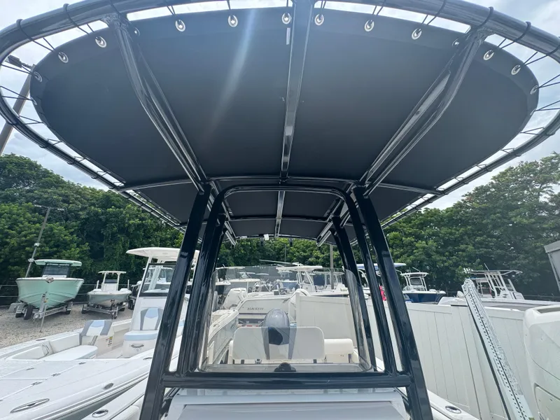 Slide: The Image of 2025 Robalo R222 Center Console boat with T-top, parked among other boats. - 11