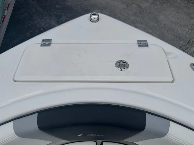 Slide: The Image of 2025 Robalo R222 Center Console boat bow storage compartment, white with metal latch. - 7
