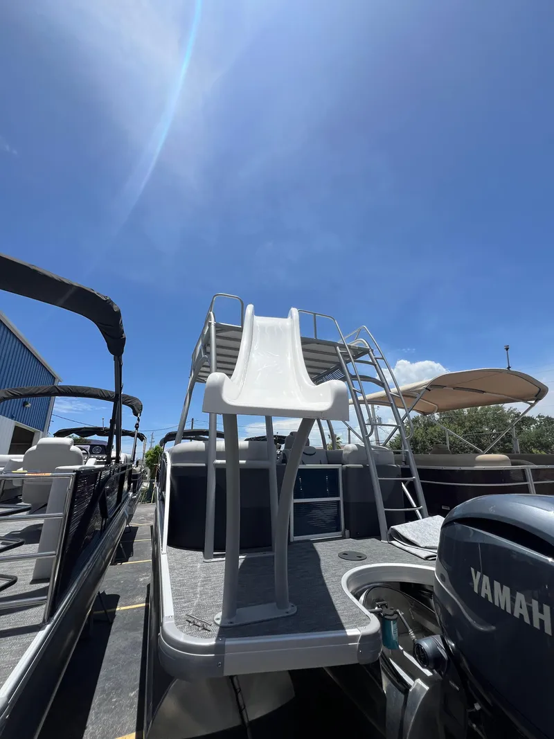 Slide: The Image of 2022 Godfrey Monaco 235 SDB pontoon boat with slide under a clear blue sky. - 15