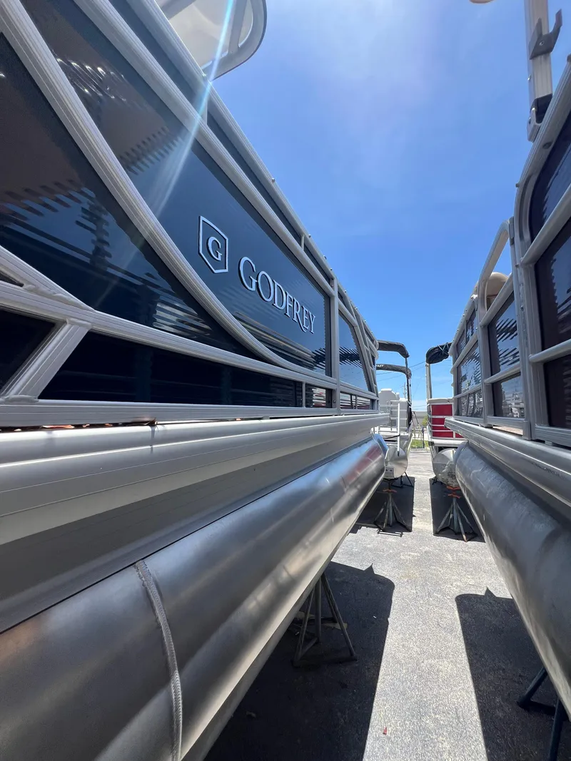 Slide: The Image of 2022 Godfrey Monaco 235 SDB pontoon boats under bright blue sky. - 20