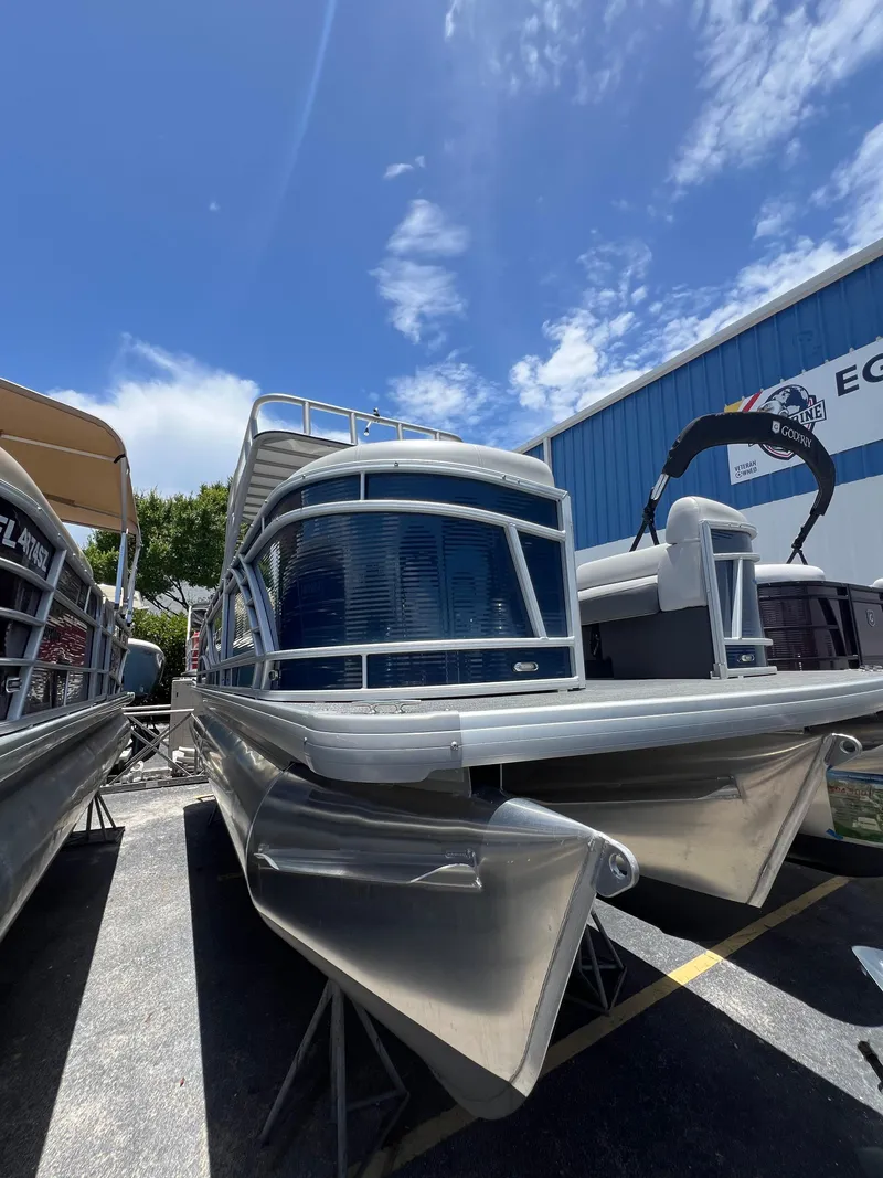 Slide: The Image of 2022 Godfrey Monaco 235 SDB pontoon boat under a clear blue sky. - 23