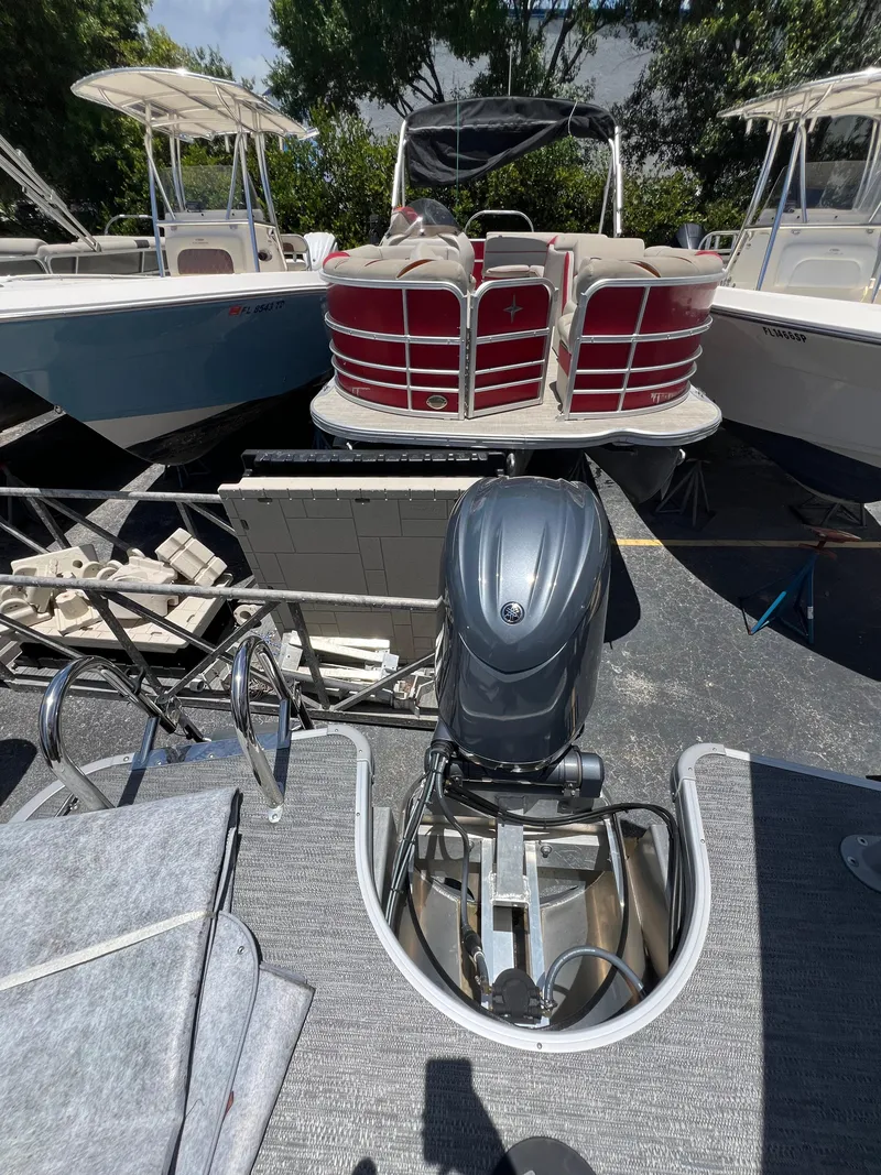 Slide: The Image of 2022 Godfrey Monaco 235 SDB pontoon boat with outboard motor, docked among other boats. - 31