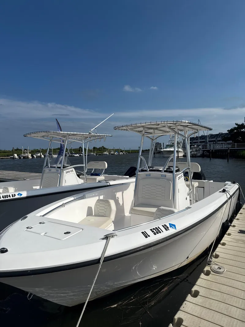 Slide: The Image of 2024 Aquasport 2200 Center Console boat docked on a sunny day. - 0