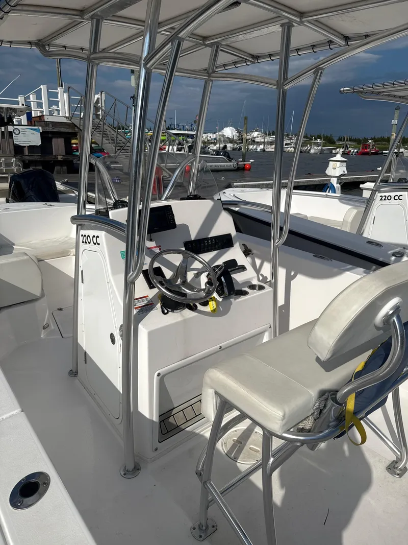 Slide: The Image of 2024 Aquasport 2200 Center Console boat interior with steering wheel and seating. - 6