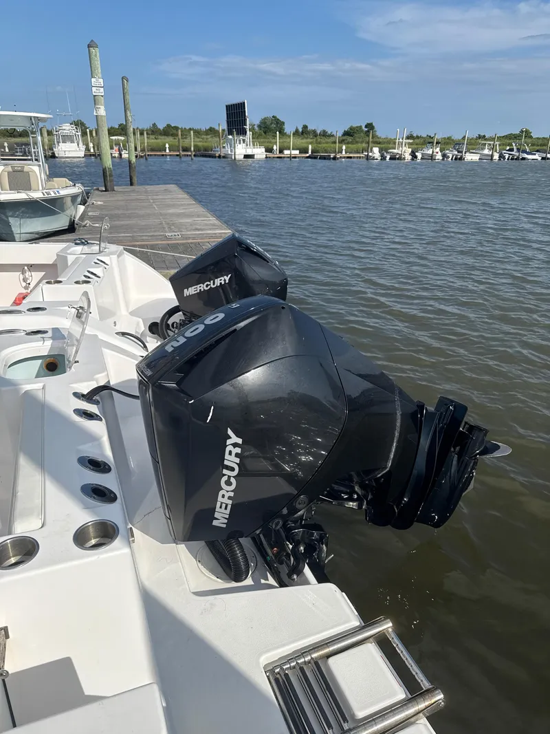 Slide: The Image of 2024 Aquasport 2200 Center Console with Mercury outboard at marina dock. - 8