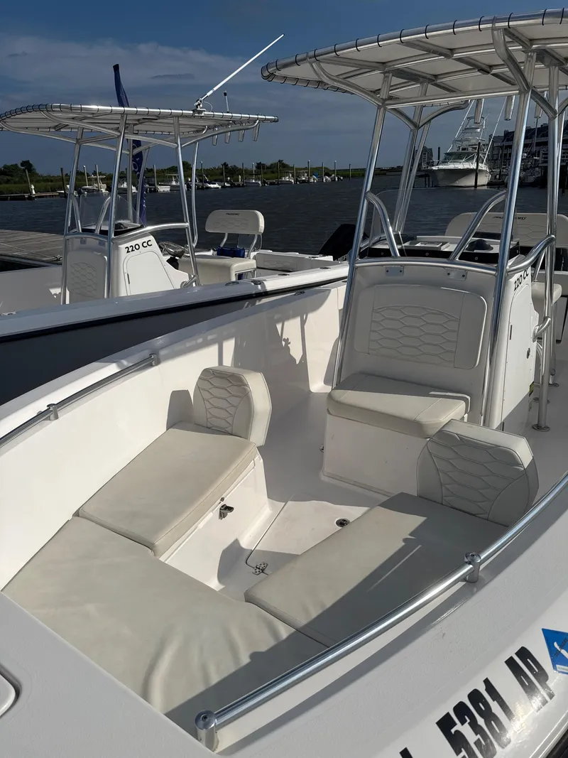 Slide: The Image of 2024 Aquasport 2200 Center Console boat with seating, docked by the water. - 9