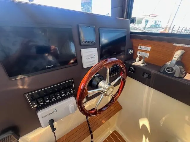 Slide: The Image of 2022 Ranger Tugs R-29 S helm with Garmin displays and wooden steering wheel. - 10