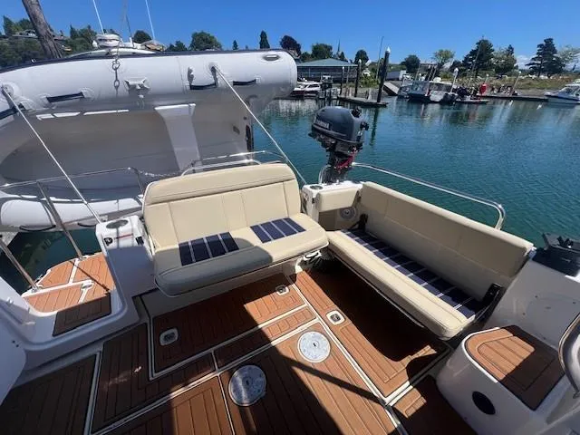 Slide: The Image of 2022 Ranger Tugs R-29 S boat deck with seating, docked by a marina. - 3