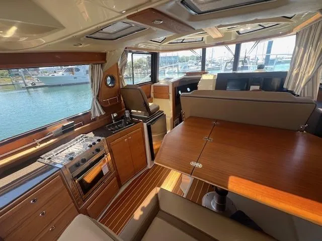 Slide: The Image of Interior of 2022 Ranger Tugs R-29 S boat with wood finishes and waterfront view. - 9