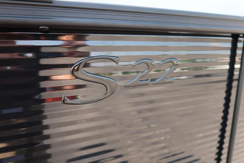 Slide: The Image of Close-up of 2026 Bennington S Quad Bench 22 SSR emblem on sleek metallic surface. - 14