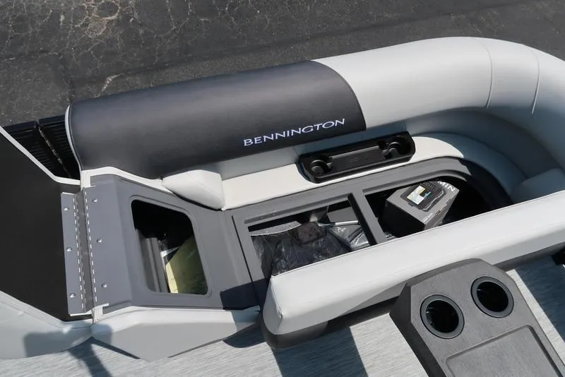 Slide: The Image of 2026 Bennington S Quad Bench 22 SSR boat interior with storage compartments and cup holders. - 18