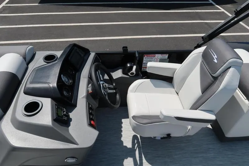Slide: The Image of 2026 Bennington S Quad Bench 22 SSR boat helm with steering wheel and captain's chair. - 4