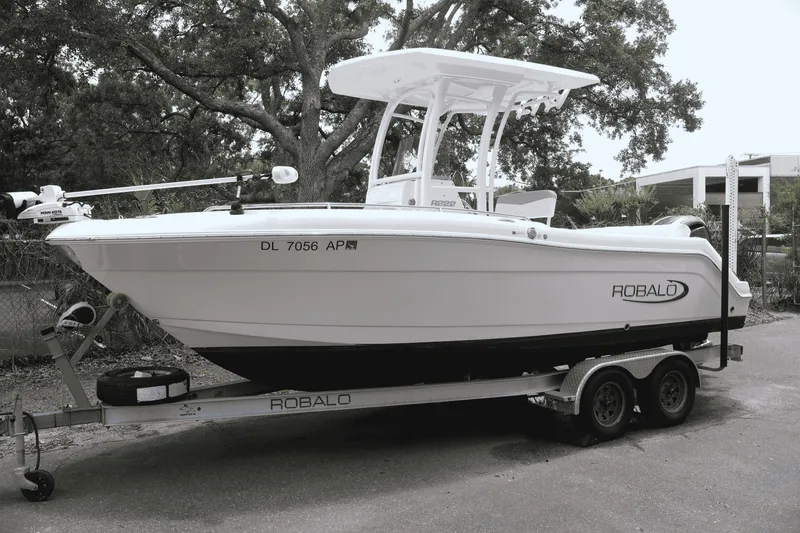 Slide: The Image of 2022 Robalo R222 Center Console boat on trailer, parked outdoors. - 1