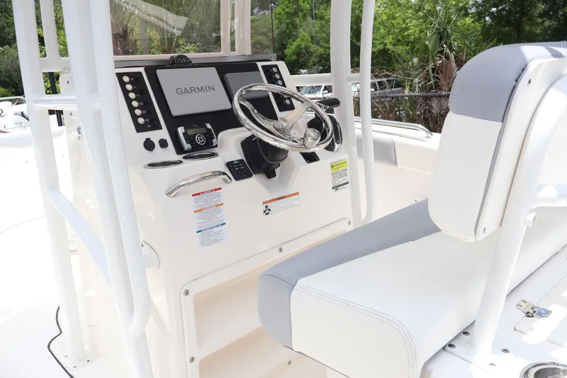 Slide: The Image of 2022 Robalo R222 Center Console boat helm with Garmin display and cushioned seating. - 12