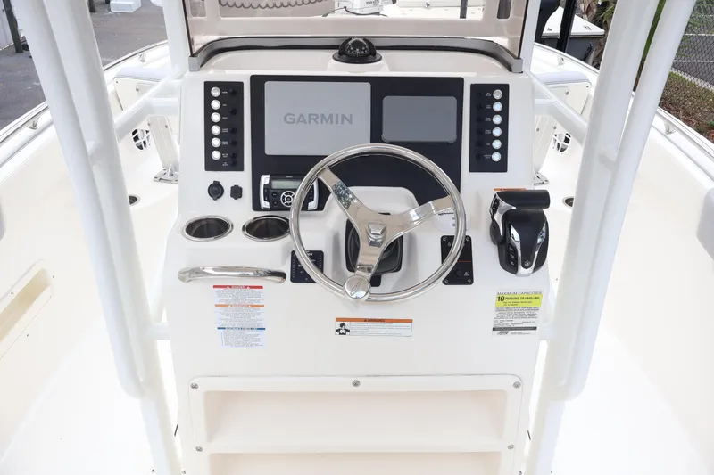 Slide: The Image of 2022 Robalo R222 Center Console boat dashboard with Garmin display and steering wheel. - 13