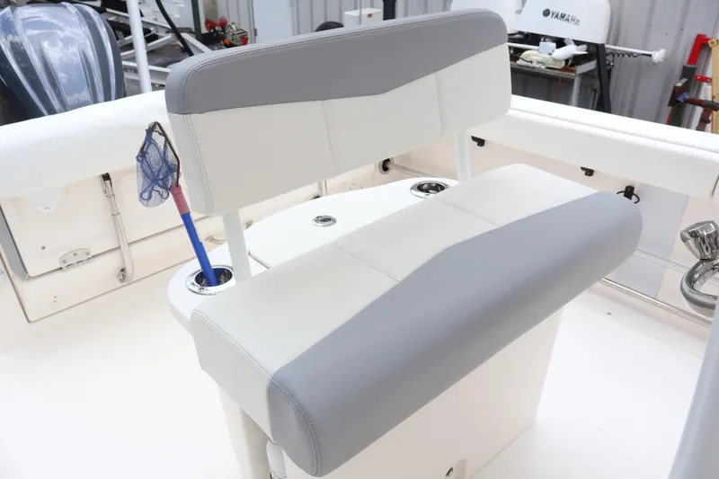 Slide: The Image of 2022 Robalo R222 Center Console boat interior with cushioned seating and fishing net. - 18