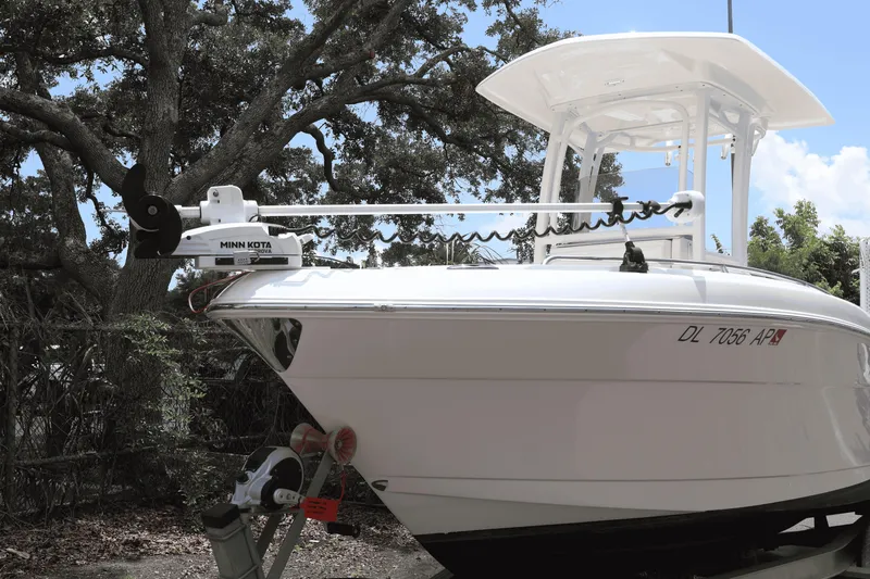 Slide: The Image of 2022 Robalo R222 Center Console boat with Minn Kota trolling motor, parked outdoors. - 2