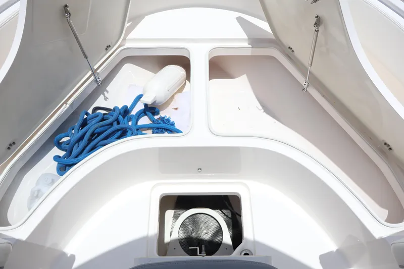 Slide: The Image of 2022 Robalo R222 Center Console storage compartments with blue rope and fender. - 6