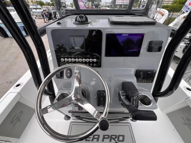 Slide: The Image of 2026 Sea Pro 230 DLX boat dashboard with steering wheel and navigation controls. - 11