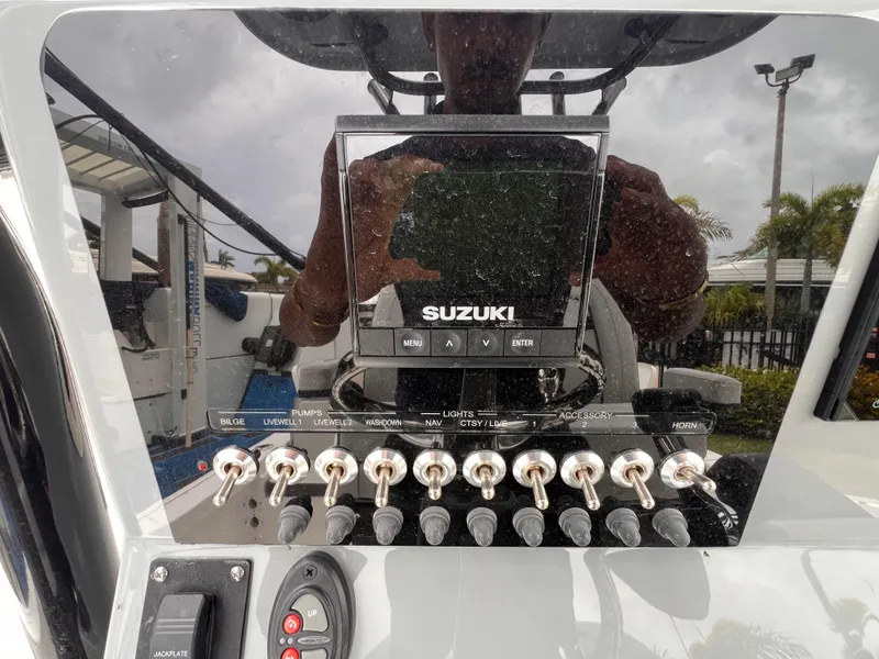 Slide: The Image of Control panel of 2026 Sea Pro 230 DLX boat with Suzuki display and switches. - 15