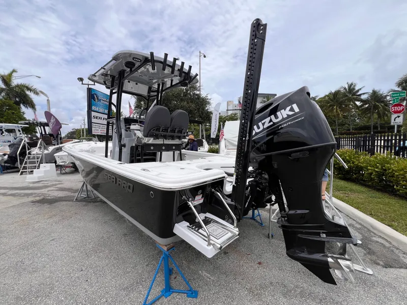 Slide: The Image of 2026 Sea Pro 230 DLX boat with Suzuki engine displayed outdoors. - 2