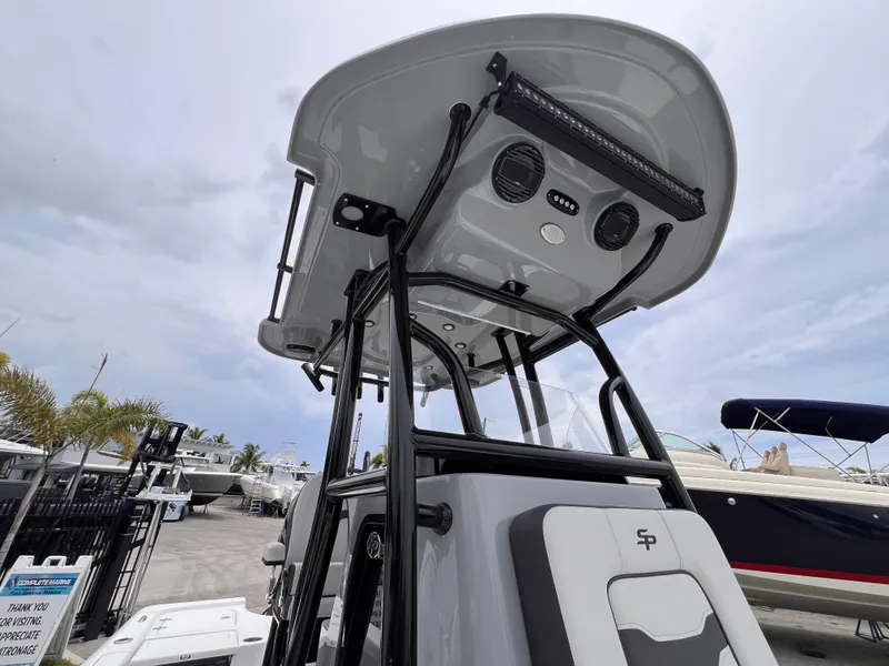 Slide: The Image of 2026 Sea Pro 230 DLX boat with T-top and modern features at a marina. - 25