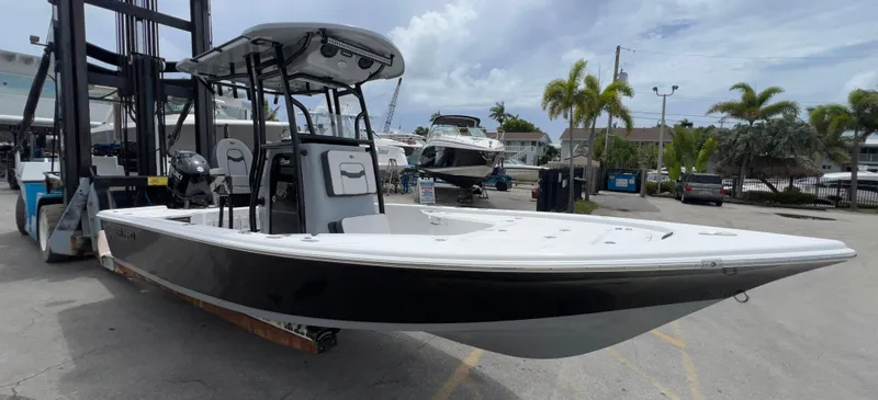 Slide: The Image of 2026 Sea Pro 230 DLX boat on a forklift at a marina, surrounded by palm trees. - 40