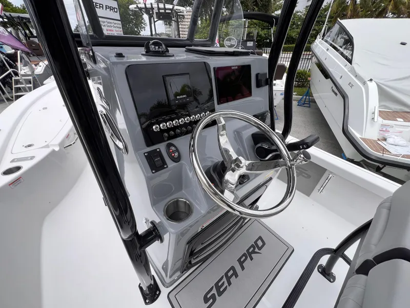 Slide: The Image of 2026 Sea Pro 230 DLX boat dashboard with steering wheel and controls. - 43