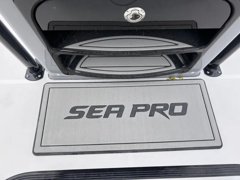 Slide: The Image of 2026 Sea Pro 230 DLX boat deck with logo and storage compartment. - 47