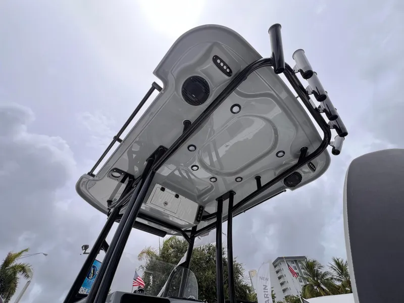 Slide: The Image of 2026 Sea Pro 230 DLX boat T-top viewed from below, against a cloudy sky. - 48