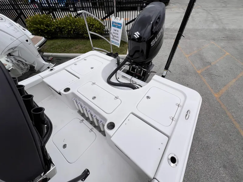 Slide: The Image of 2026 Sea Pro 230 DLX boat deck with Suzuki outboard motor, storage compartments, and rod holders. - 6