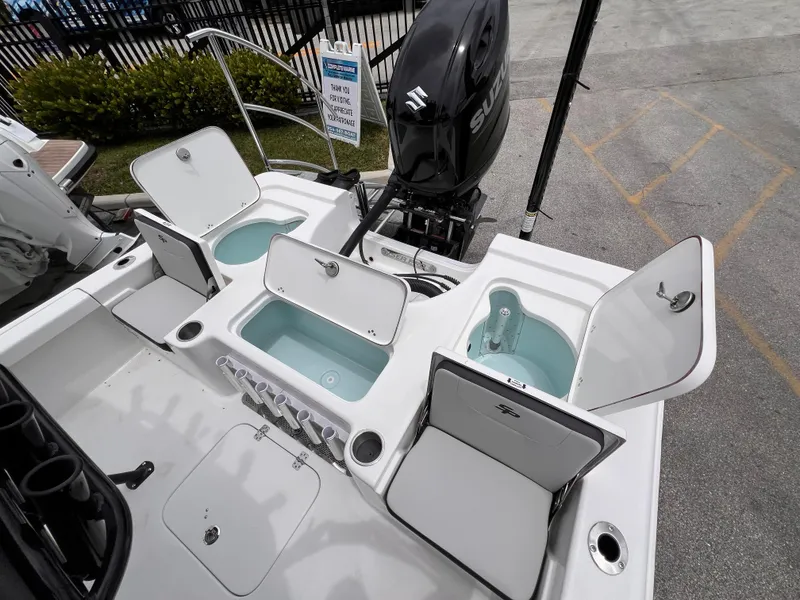 Slide: The Image of 2026 Sea Pro 230 DLX boat with open storage compartments and Suzuki outboard motor. - 8