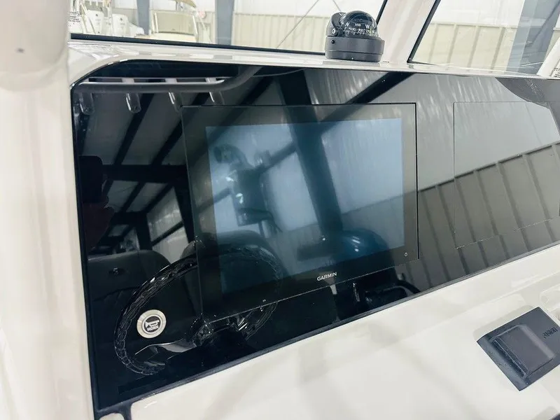 Slide: The Image of 2025 Sportsman MASTERS 247OE boat dashboard with Garmin display and compass. - 3