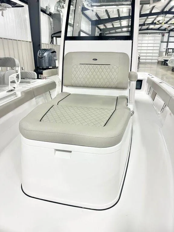 Slide: The Image of 2025 Sportsman MASTERS 247OE boat interior with cushioned seating in a modern showroom. - 6