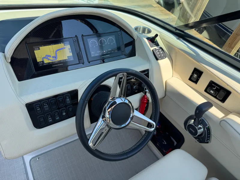 Slide: The Image of 2021 Regal 2800 boat dashboard with steering wheel, navigation screens, and control panel. - 18