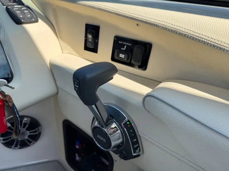 Slide: The Image of Interior of a 2021 Regal 2800 boat showing throttle controls and seat adjustment panel. - 20