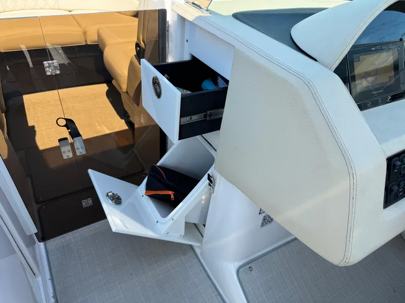 Slide: The Image of 2021 Regal 2800 boat interior with open storage compartments and beige seating. - 22