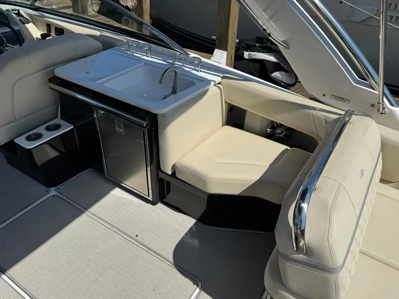 Slide: The Image of 2021 Regal 2800 boat interior with sink, seating, and mini fridge. - 8
