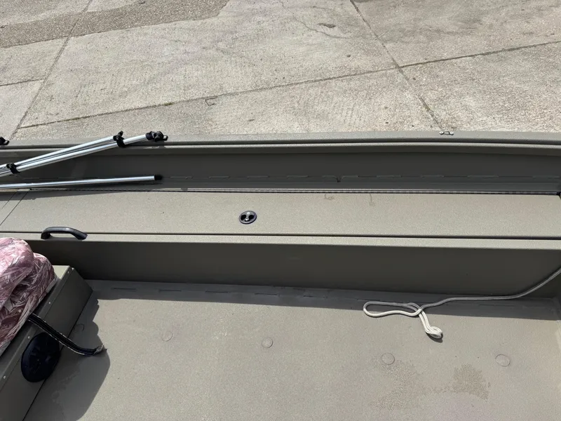 Slide: The Image of 2021 Alumacraft 2072 SC boat interior with storage compartment and fishing rod holders. - 12