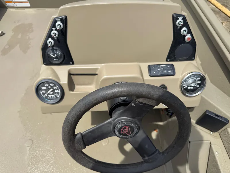 Slide: The Image of 2021 Alumacraft 2072 SC boat dashboard with steering wheel and control gauges. - 9
