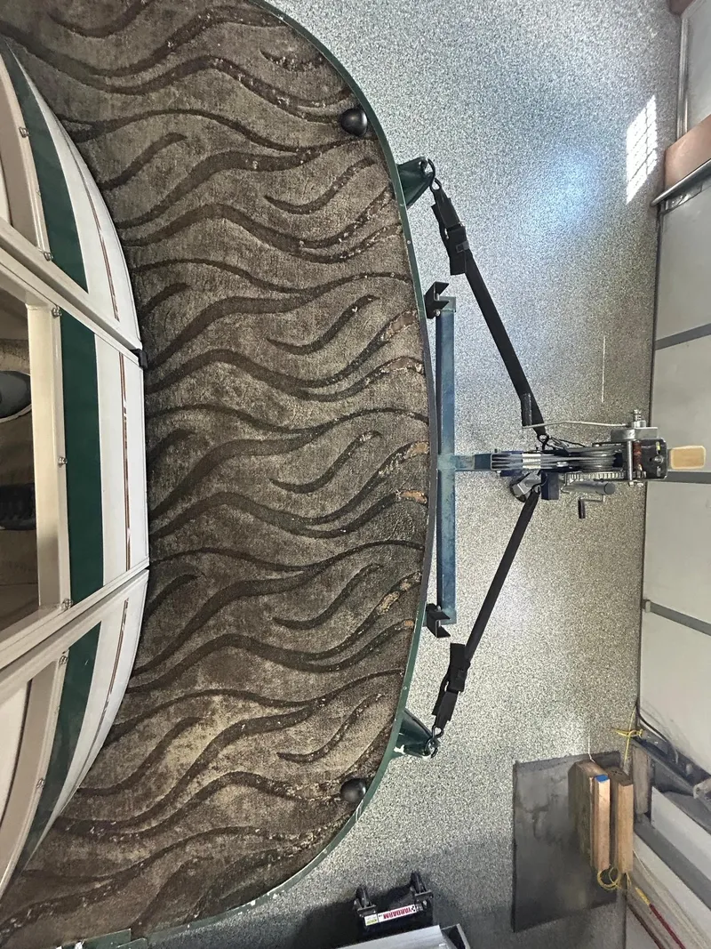 Slide: The Image of 2003 Crestliner LSi Angler 2485 boat with patterned carpet in a garage setting. - 7