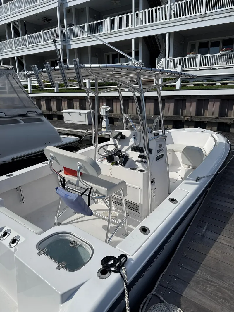 Slide: The Image of 2023 Aquasport 2200 Center Console boat docked near waterfront building. - 3