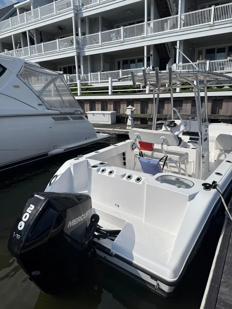 Slide: The Image of 2023 Aquasport 2200 Center Console boat docked with Mercury 200 V6 engine. - 4