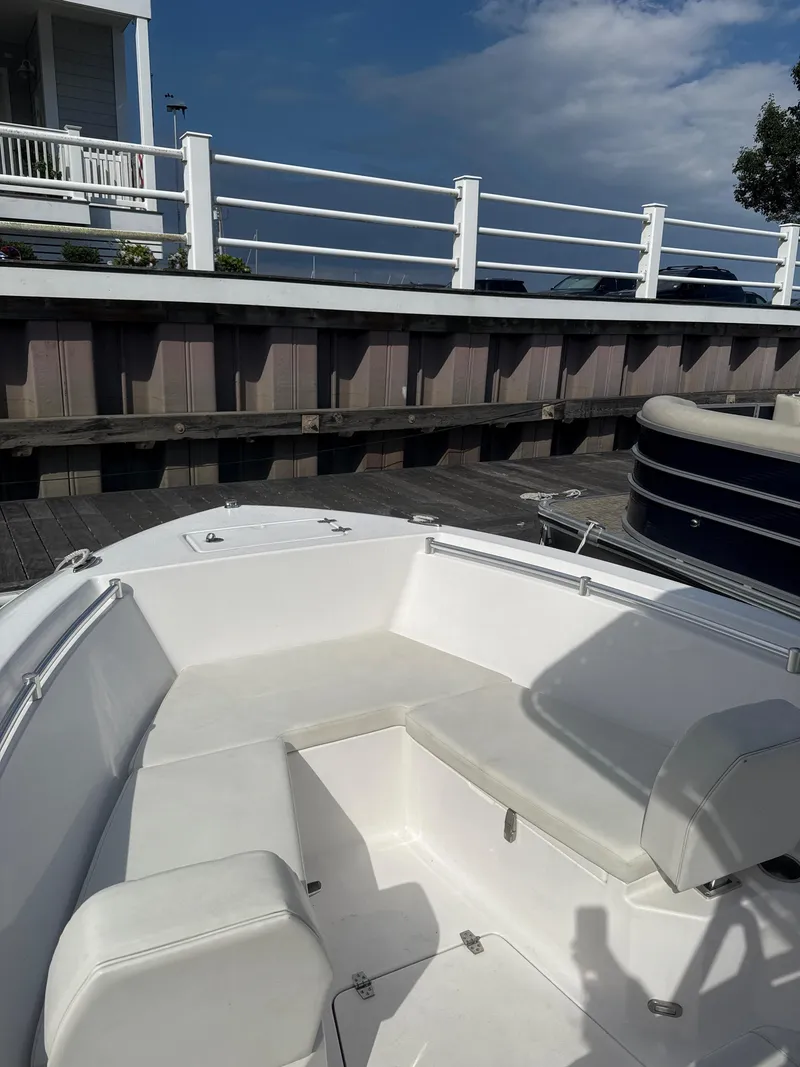 Slide: The Image of 2023 Aquasport 2200 Center Console boat interior with white seating at dock. - 6