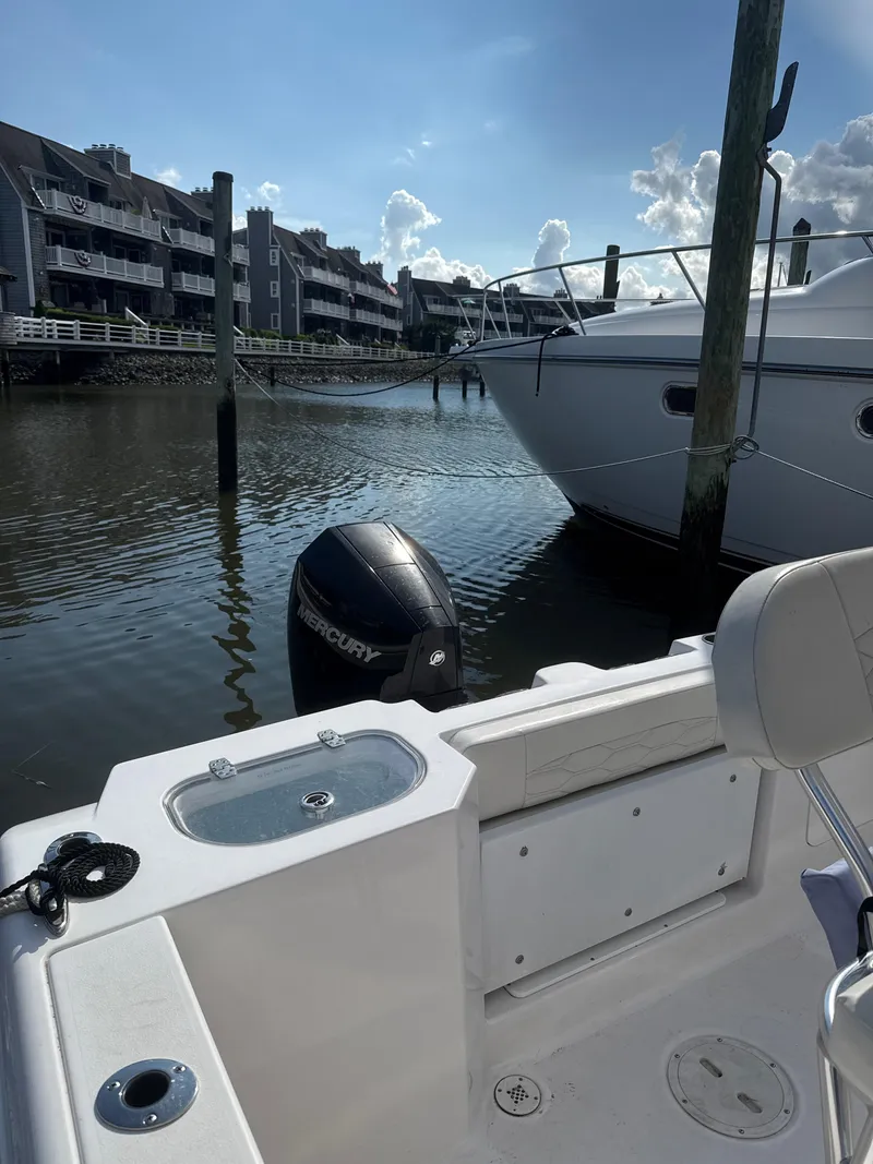 Slide: The Image of 2023 Aquasport 2200 Center Console boat docked near waterfront homes. - 8