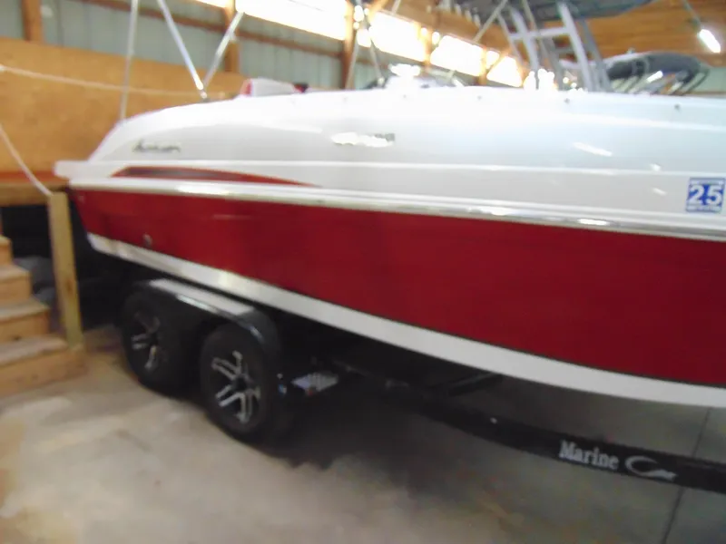 Slide: The Image of 2021 Hurricane SunDeck Sport 188 IO boat in storage, red and white exterior, on a trailer. - 3
