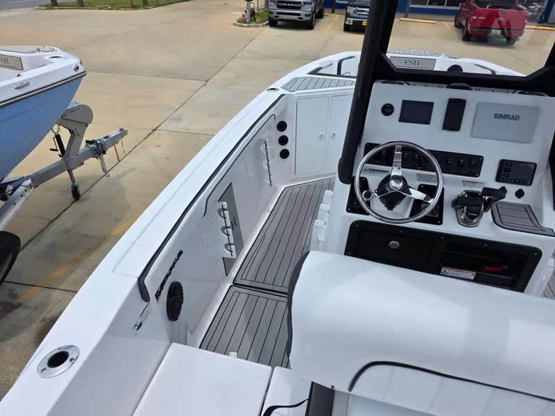 Slide: The Image of 2025 Yamaha Boats 222 FSH Sport E interior with steering console and seating. - 12